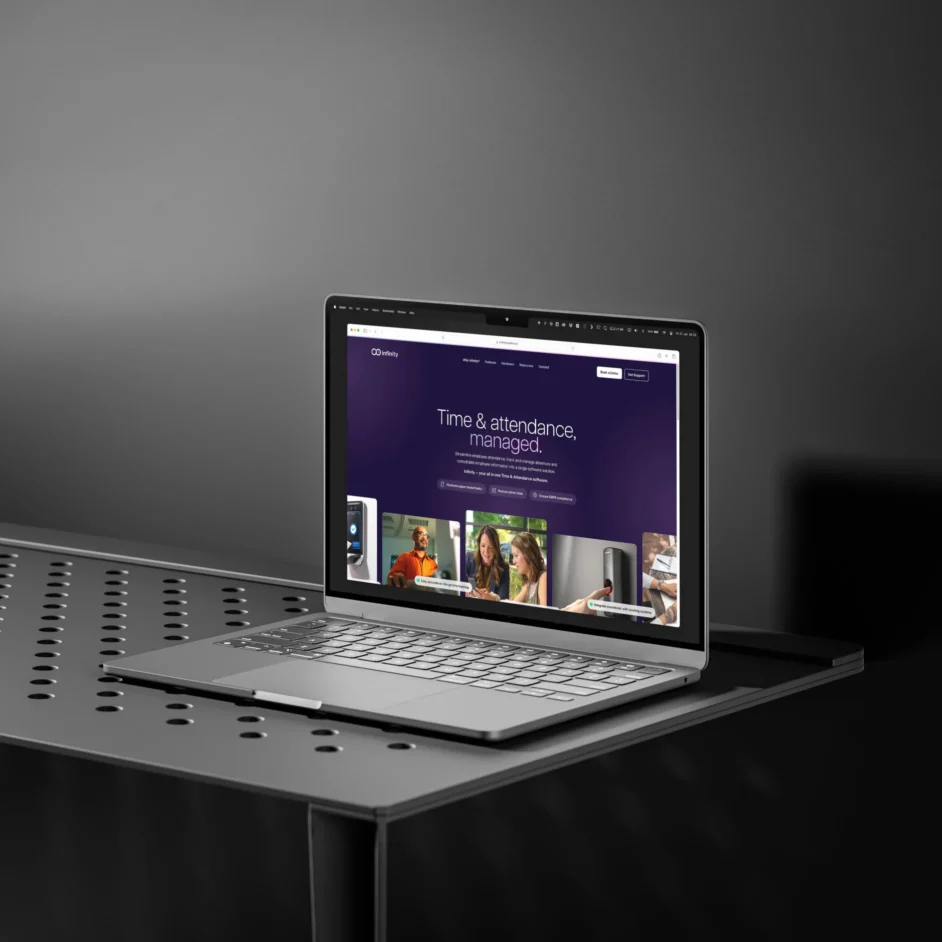 I Macbook on a metallic table showing Infinity website homepage.