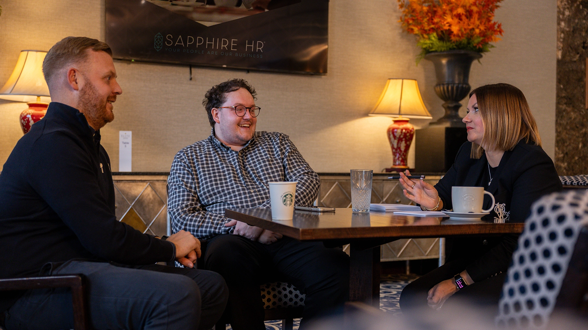 Michael Dobson and two Sapphire HR colleagues chatting around table.