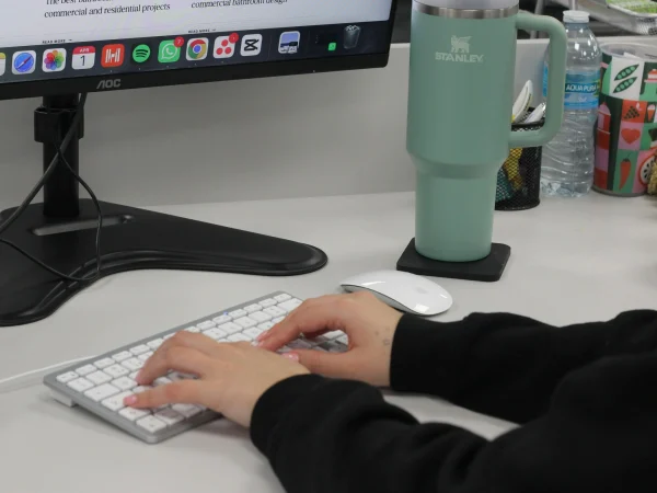 A TVG team member's hands typing on an Apple keyboard.