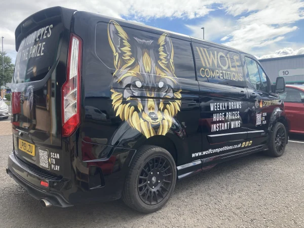 A black van with the Wolf competition logo in the TVG car park. 